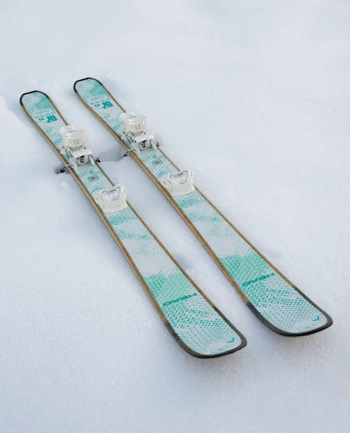 Head Kore 87 Ti Women skidor i vitt utförande med bindningar stående i snön.