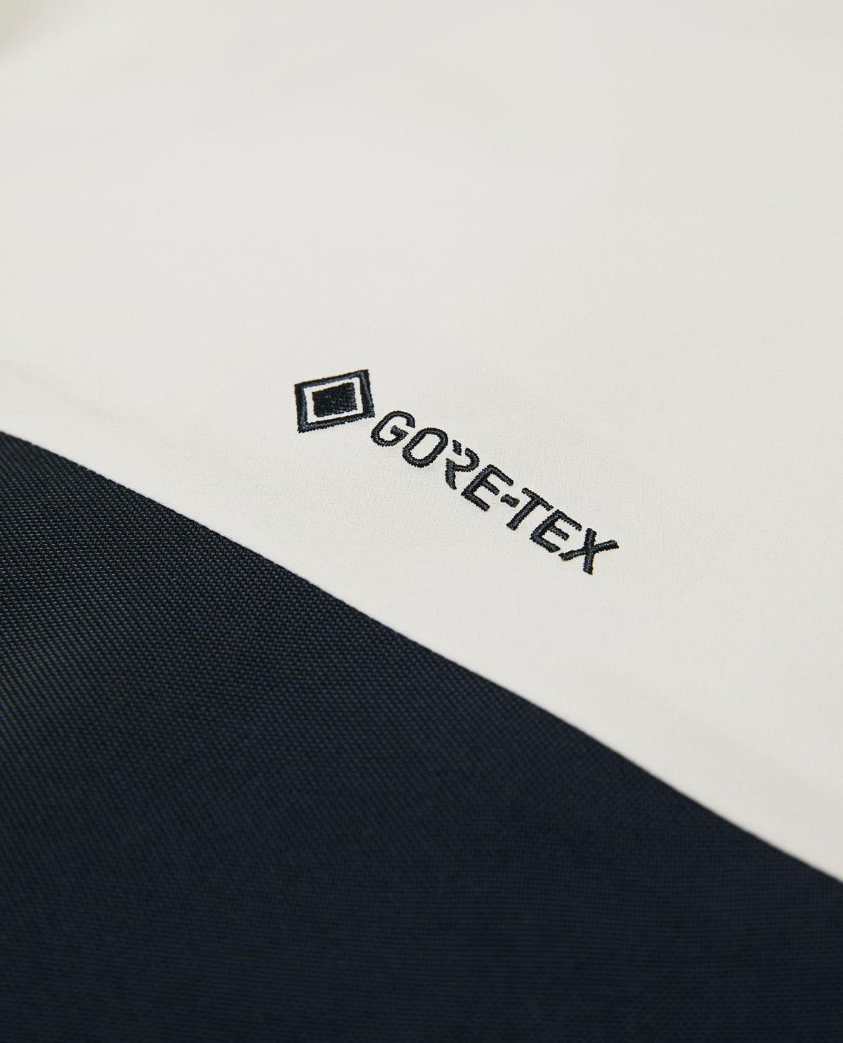 Närbild på GORE-TEX-logotypen på Peak Performance Alpine Gore-Tex 3L Pants Women i färgen Sand Fog.