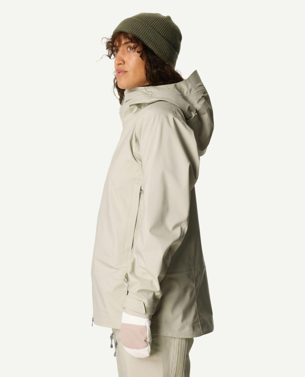 Kvinna i profil som bär Houdini Ride Jacket II Women i färgen Greenish Gray och grön mössa.