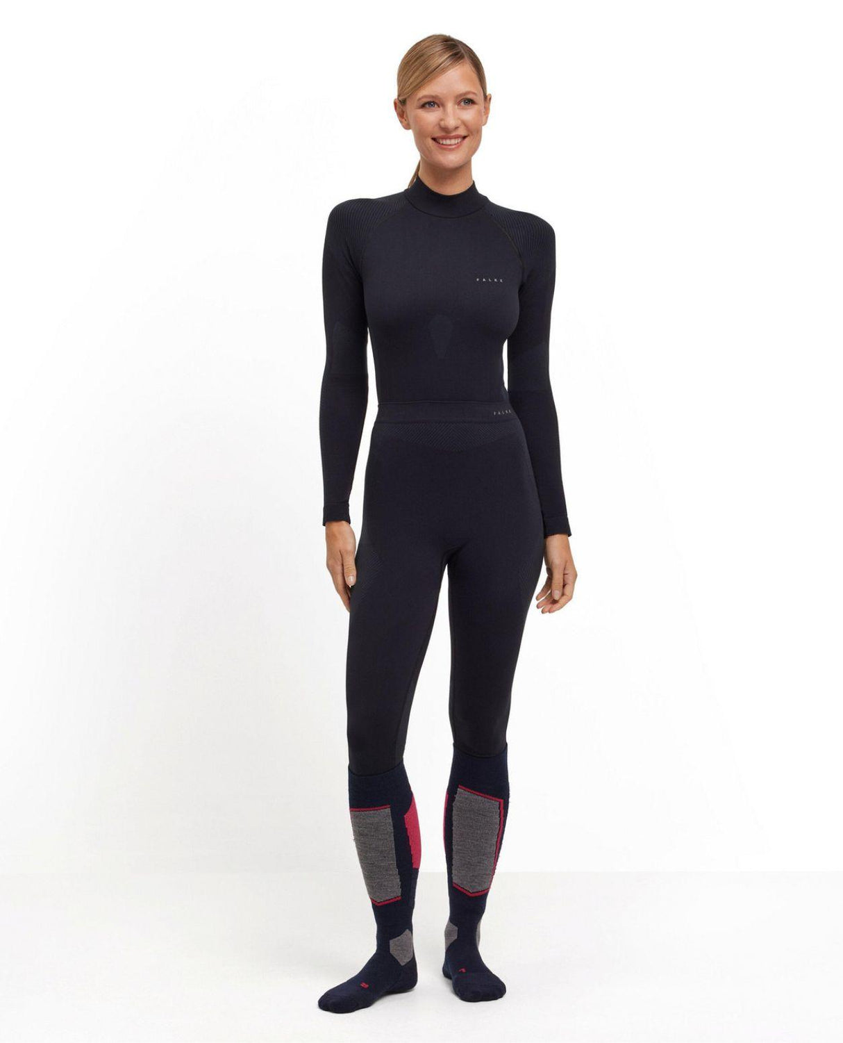 Kvinna som bär Falke Warm Long Tights Women i svart färg tillsammans med matchande underställströja.