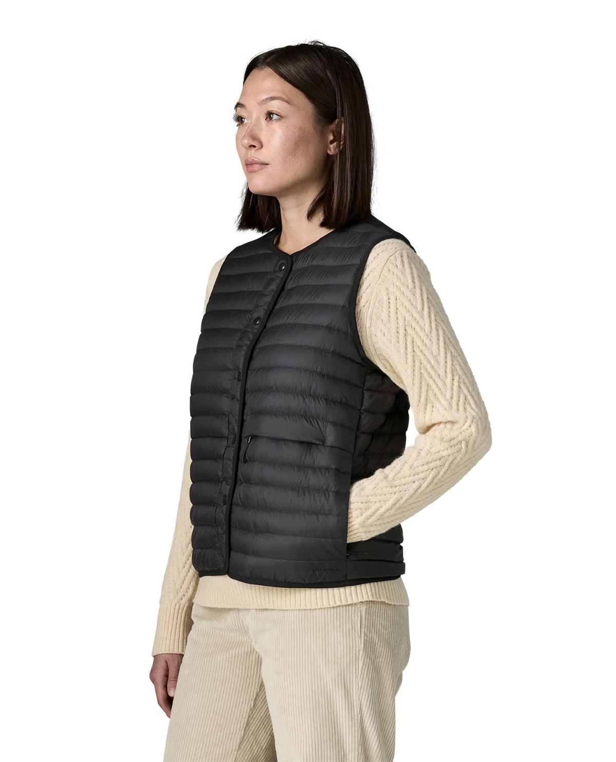 Patagonia LW Reversible Down Sweater Vest Women i svart färg bärs av modell i profil.
