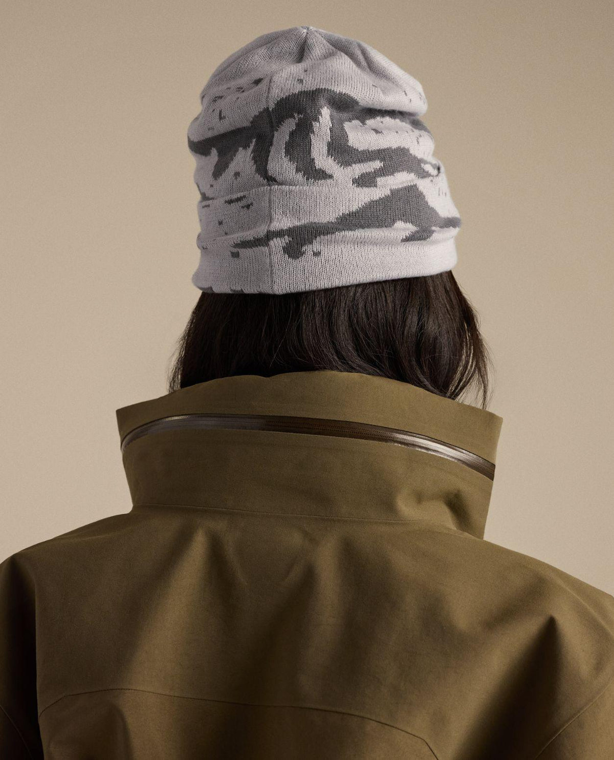 Arc'teryx Grotto Toque i grått och mörkt mönster sett bakifrån på person med grön jacka.