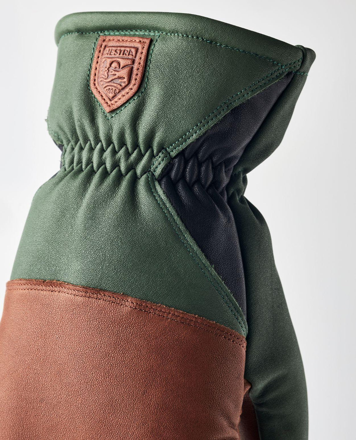 Hestra reMix Mitt läderhandske i grön och brun design med elastisk handled och broderad logotyp.