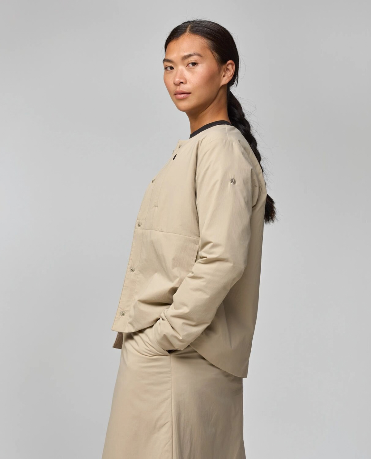 Fjällräven HC Insulated Jacket Women i färgen fossil som visar jackans sidoprofil och passform för dam.