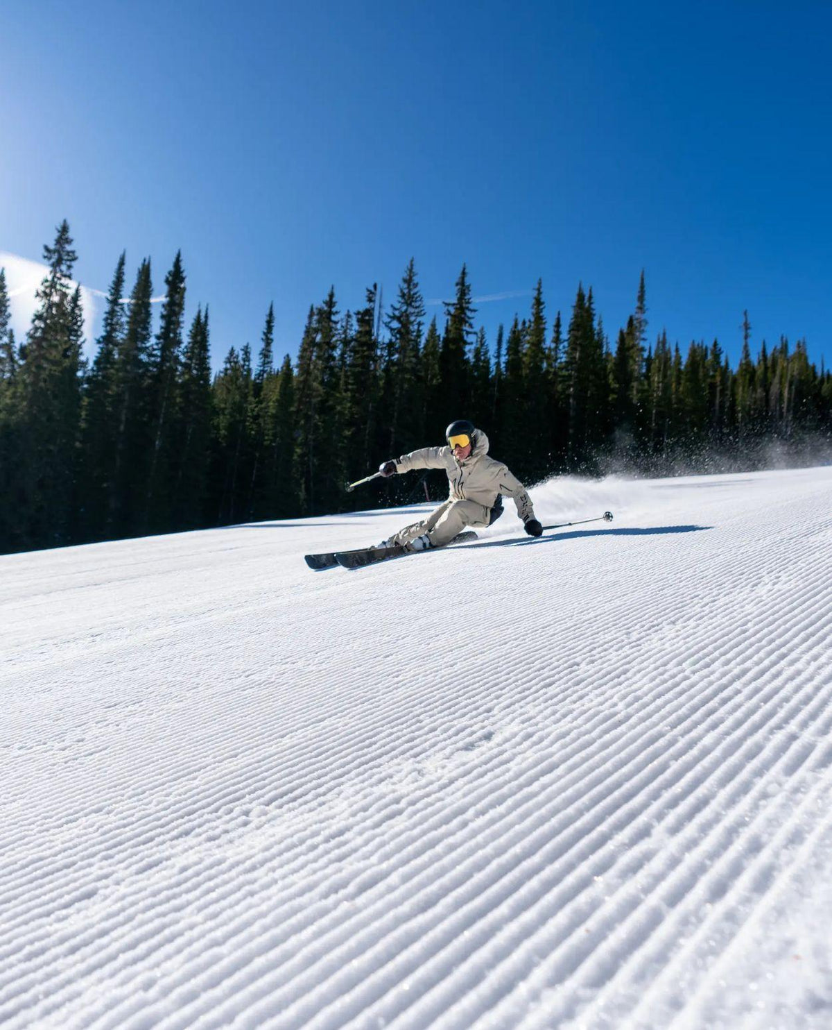 Skidåkare carvar i nypistad backe med Head Kore 94 Ti-skidor under en solig dag.
