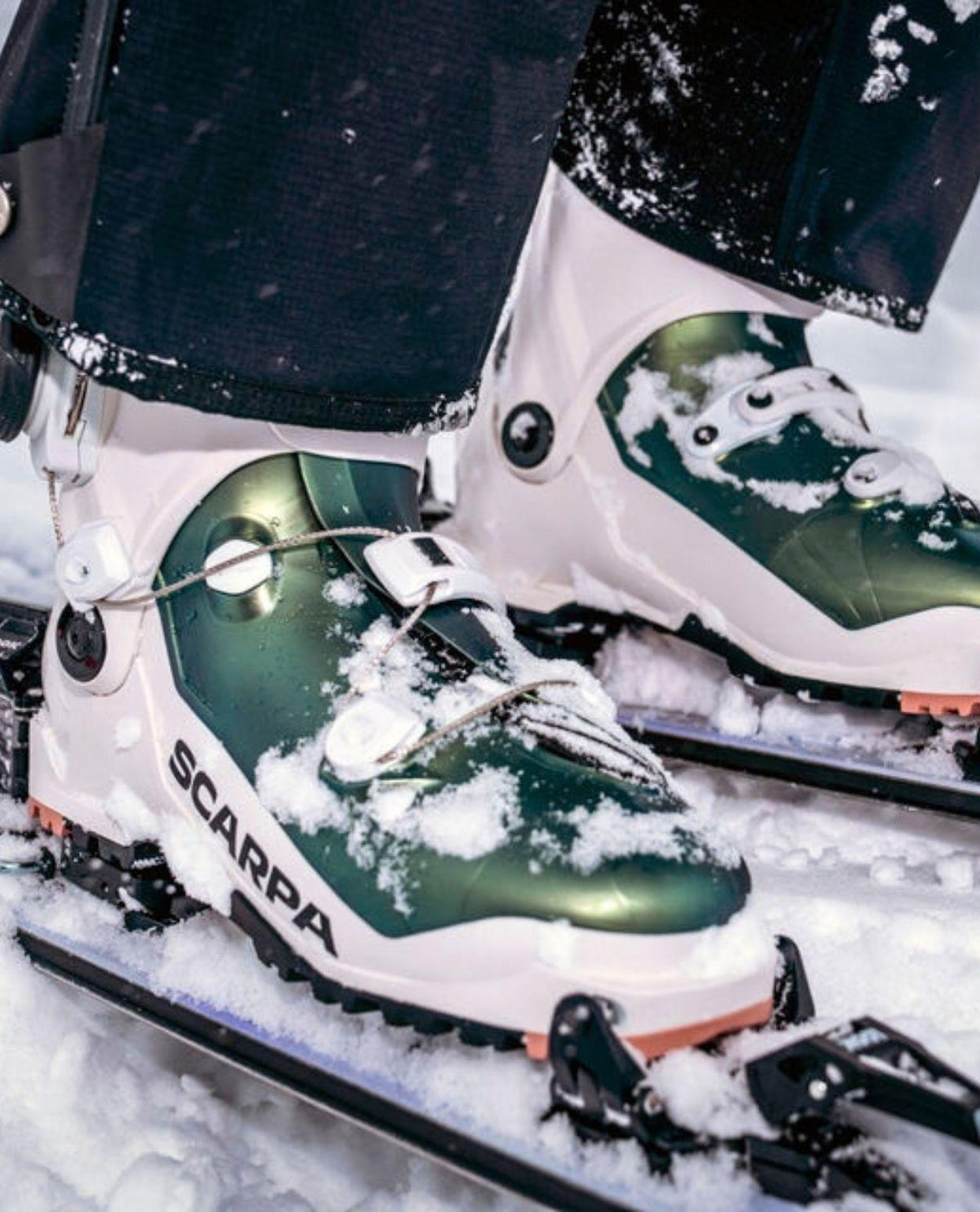 Scarpa F1 RS Women toppturspjäxor i vitt och grönt med snö i vintermiljö