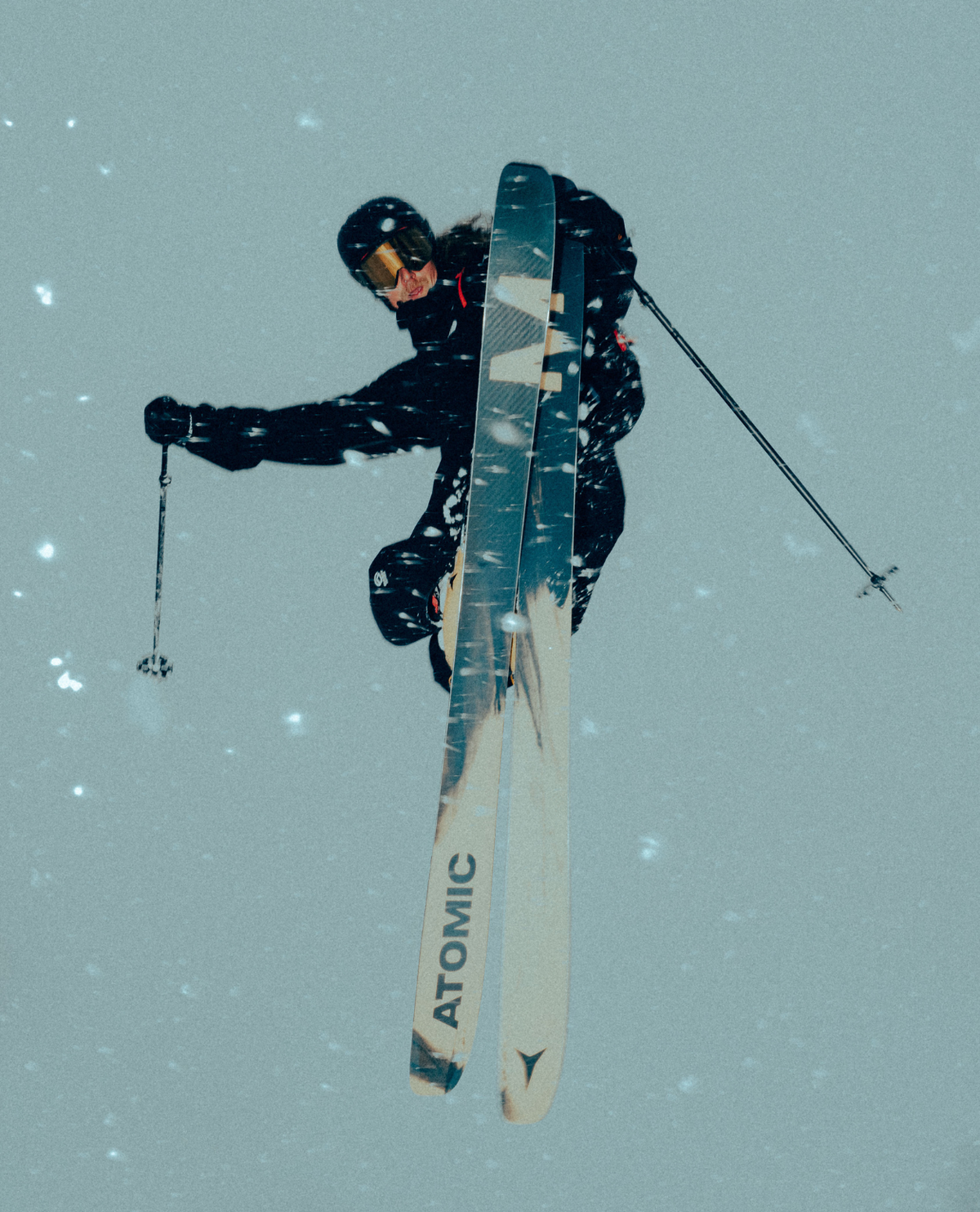 Skidåkare i luften med Atomic Maverick 115 CTI 26/27 freerideskidor i djupsnö och snöfall.