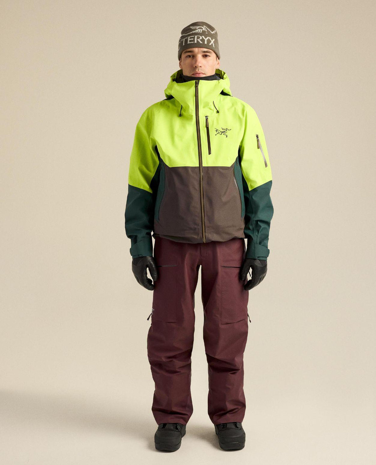 Arc'teryx Sabre Bib Men skidbyxor i lila färg på modell tillsammans med skidjacka och mössa.