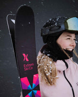 Glada skidåkare med svarta Extrem Ski Co Factory 102 friåkningsskidor i snöfall.