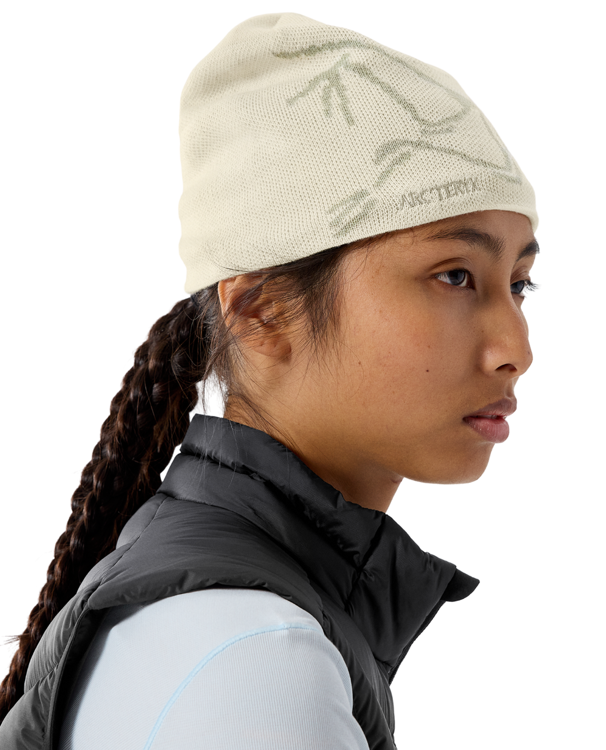 Arc'teryx Bird Head Toque mössa i färgerna Sea Salt och Kasumi på en modell i profil.
