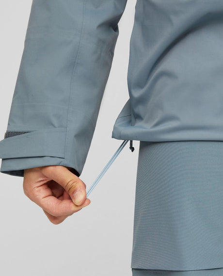 Mammut Haldigrat HS Hooded Jacket för herrar visar justering av dragsko i nederkant på den gråblå hardshelljackan.