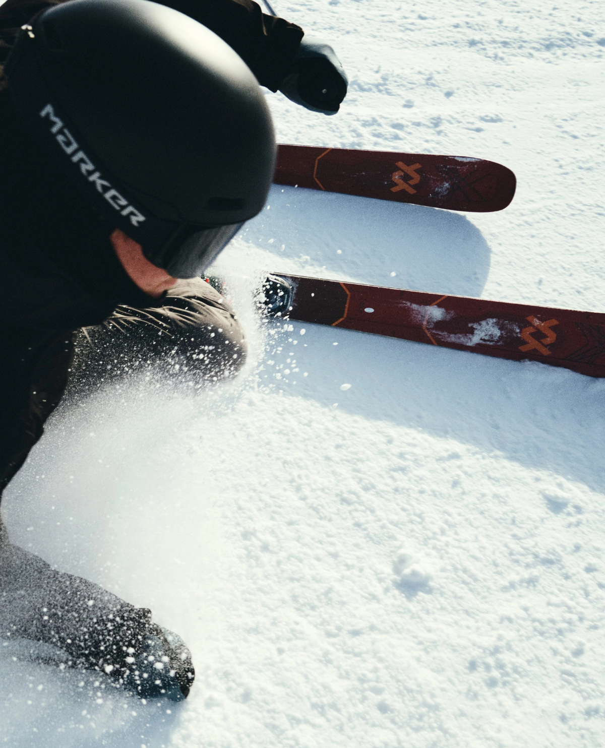 Skidåkare i fart som svänger med Völkl M7 Mantra allmountainskidor i snön.