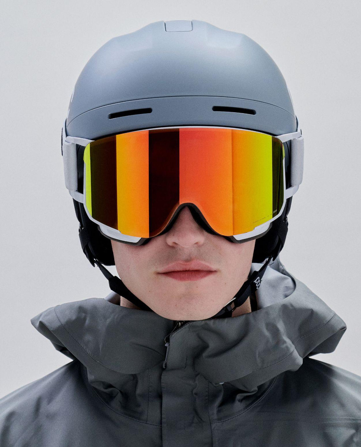 Skidåkare i hjälm bärandes POC Nexal goggles i Hydrogen White med orange spegellins.