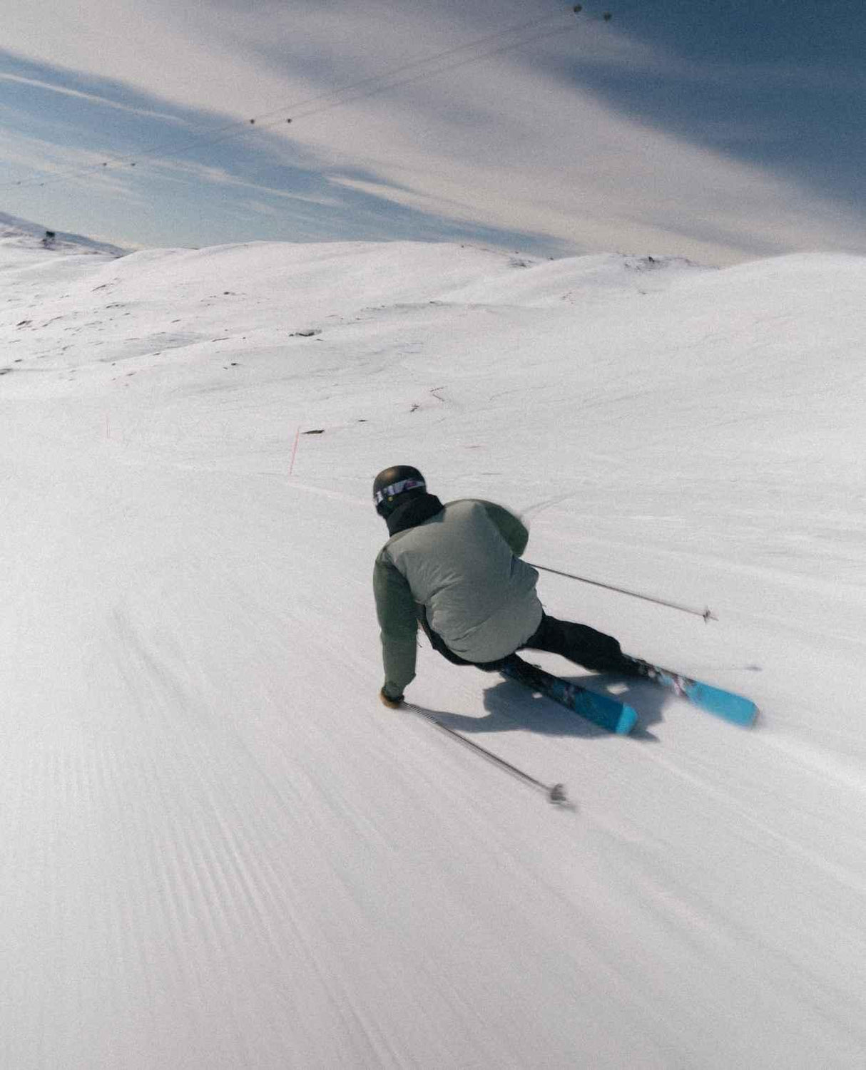 Skidåkare carvar i pisten med Extrem Factory 96 allmountainskidor under en solig dag i fjällen.