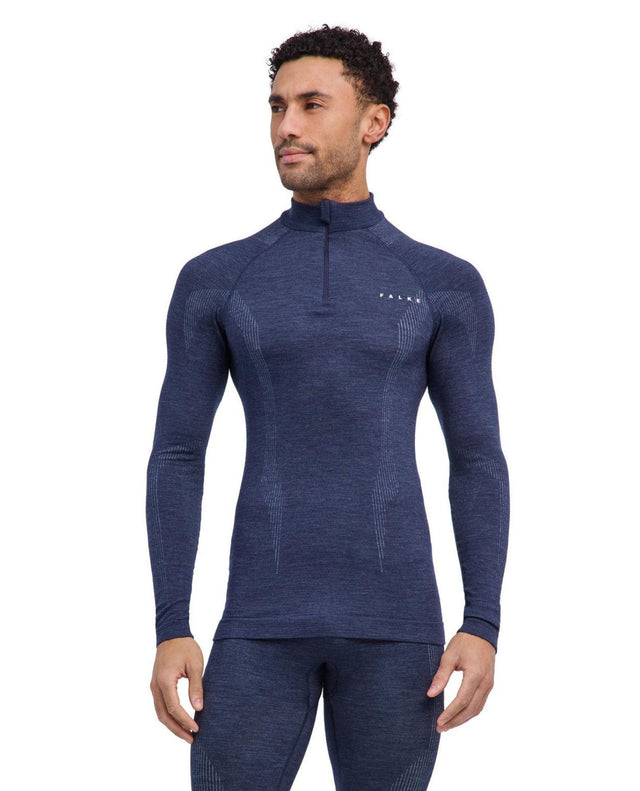 Manlig skidåkare iförd den blå långärmade funktionströjan Falke Wool-Tech Longsleeve Zip i färgvarianten Space Blue.