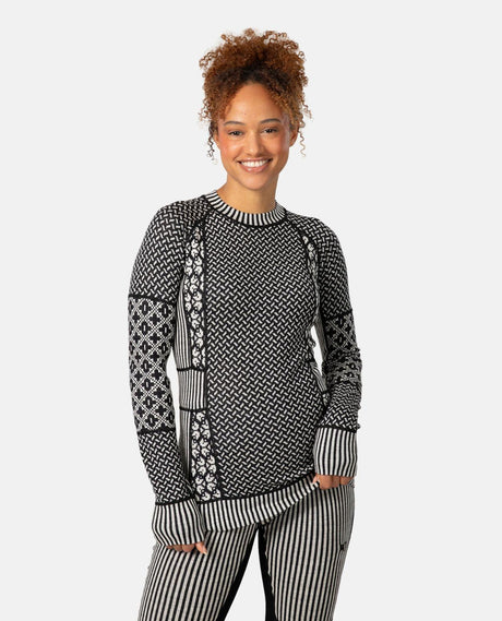 Kvinna som bär Kari Traa Smekker Long Sleeve i svart med jacquardstickat mönster för skidåkning.