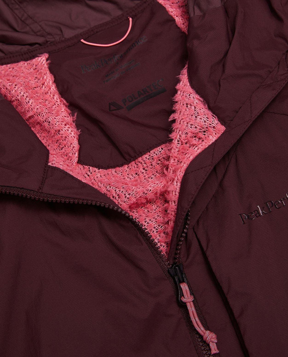 Närbild på insidan och kragen av Peak Performance Freelight Alpha Jacket Women i färgen porto med rosa Polartec-foder.