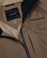 Närbild på innerfoder, etikett och broderad logotyp på Peak Performance Alpine Gore-Tex Insulated Jacket i färgen Terrain Tan.