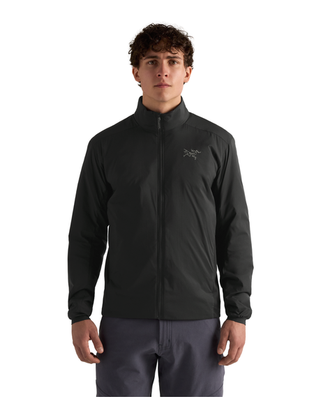 Manlig modell i svart Arc'teryx Atom Jacket, ett smidigt och varmt mellanlager för skidåkning.