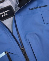 Närbild på dragkedja och detaljer på Peak Performance Alpine Gore-Tex 3L Jacket Men i färgen Summit Sky.