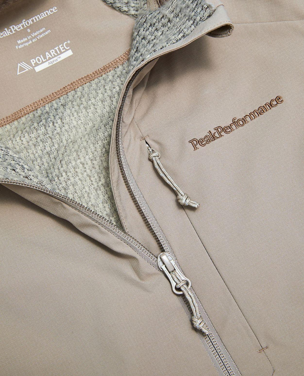 Närbild på dragkedja och Polartec-detalj på damtröja från Peak Performance i färgen Ray.