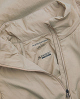 Närbild på insidan och kragen av Peak Performance Freelight Hybrid Liner Men i färgen Avid Beige med Polartec Alpha-detalj.