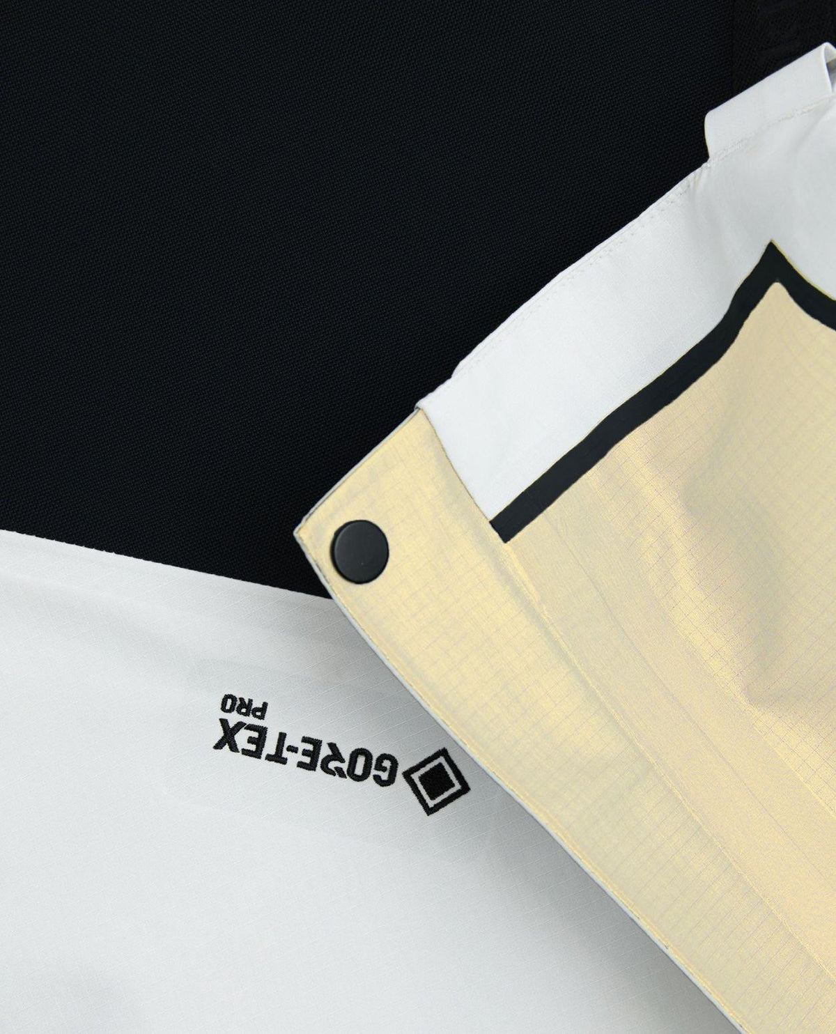 Närbild på Gore-Tex Pro-detaljerna på Peak Performance Vertical Bib Pants för damer i vitt.