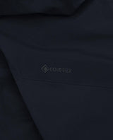Detaljbild på den svarta Gore-Tex-logotypen på Peak Performance Alpine Gore-Tex Insulated skidbyxor för herr.
