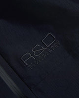 Detaljbild på broderad R&D-logotyp på svarta skidbyxor från Peak Performance.