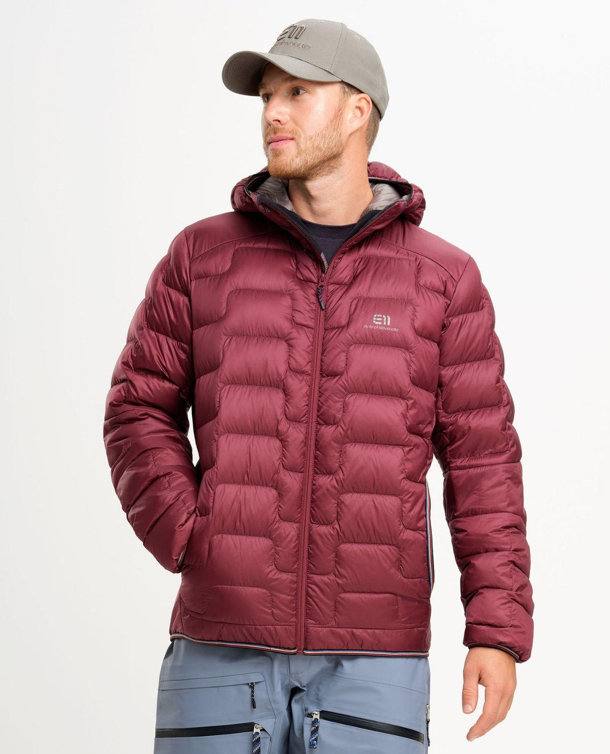 Elevenate Motion Down Hood Men i färgen Tibetan Red på modell som visar dunjackans passform och huva.
