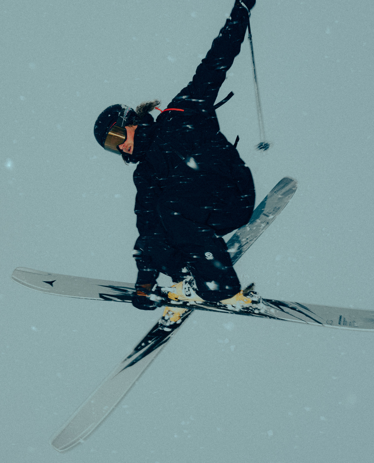 Freerideåkare som utför ett hopp med Atomic Maverick 115 CTI 26/27 i djupsnö under tätt snöfall.