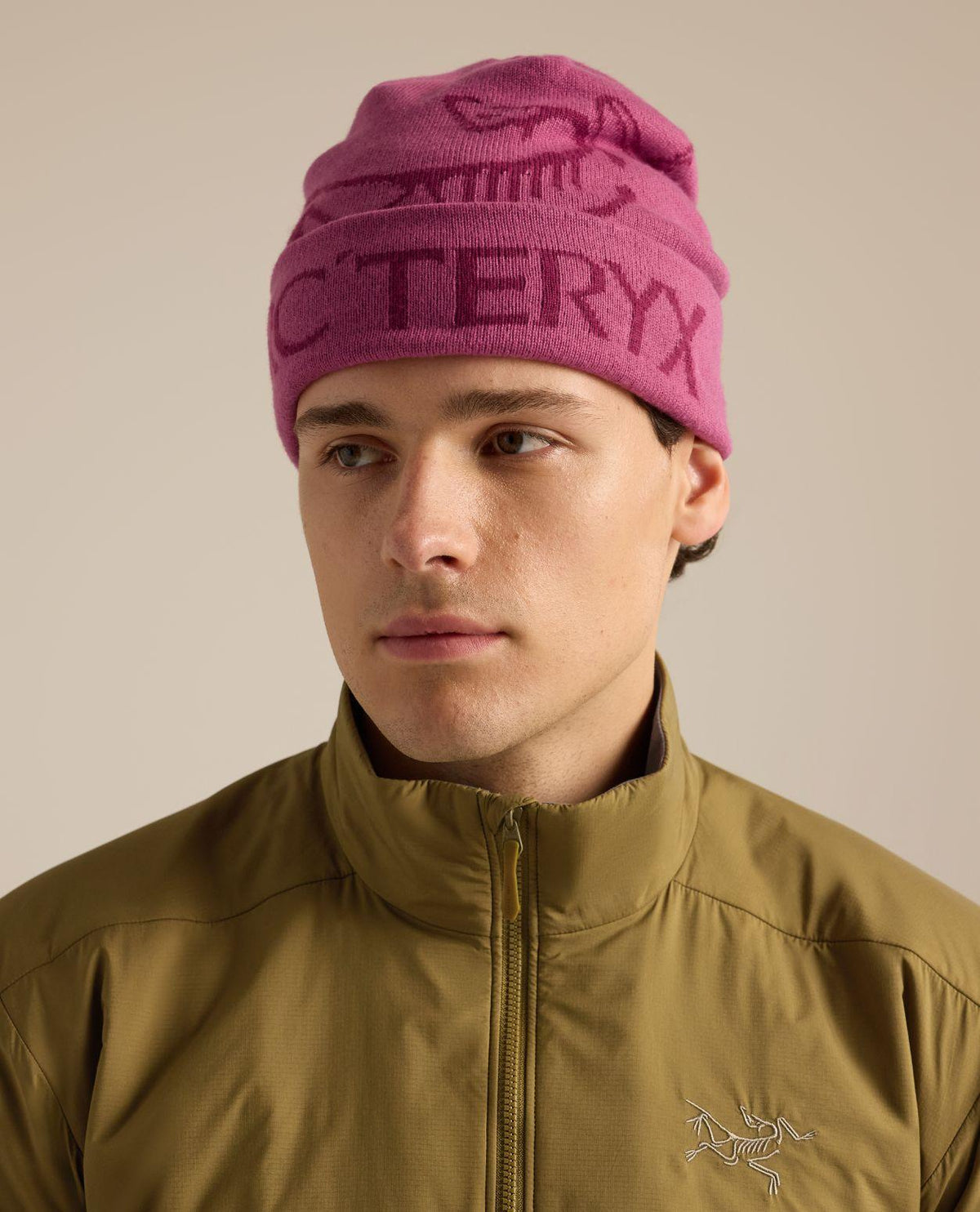Arc'teryx Bird Word Toque i rosa färg som bärs av en modell, perfekt för skidåkning och friluftsliv – Alpingaraget