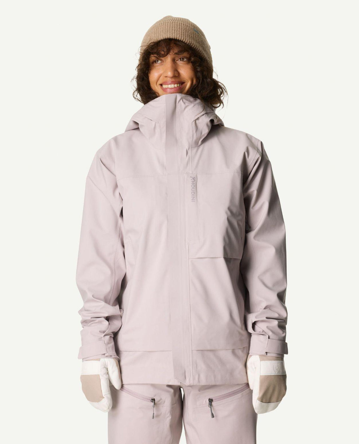 Kvinna iklädd lila Houdini Rollercoaster Jacket II, matchande byxor, mössa och vantar.