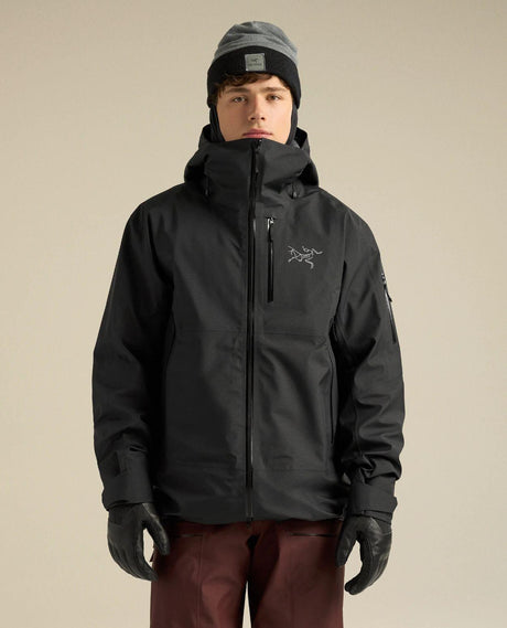 Man i svart Arc'teryx Sabre Jacket skidjacka med väderbeständigt material och huva.