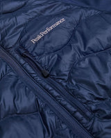 Närbild på Peak Performance Helium Down Hybrid Jacket i blått som visar bröstficka och logotyp.