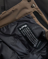 Detaljbild på insidan och etiketten för Peak Performance Gravity Insulated Pants Junior i brunt.