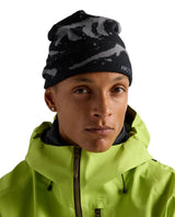 Arc'teryx Grotto Toque i svart och void, bärd av en modell i grön jacka.
