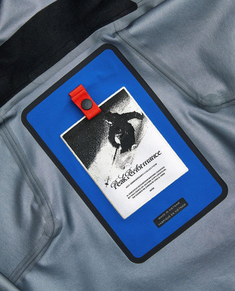 Närbild på inneretikett och logotyp i Peak Performance 40Y R&D Long Gore-Tex Shell Jacket Men i Ice Peak Blue.