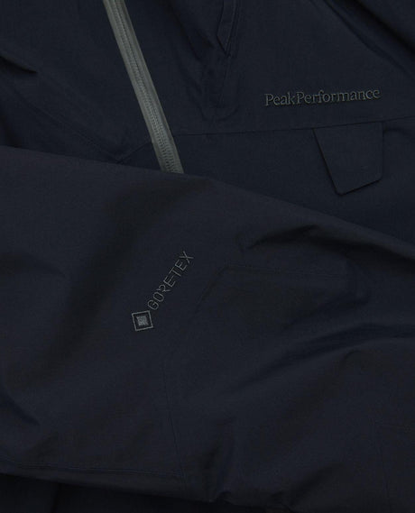 Närbild på Peak Performance Alpine Gore-Tex Insulated Jacket Dam i svart, som visar Gore-Tex-logotypen på ärmen.
