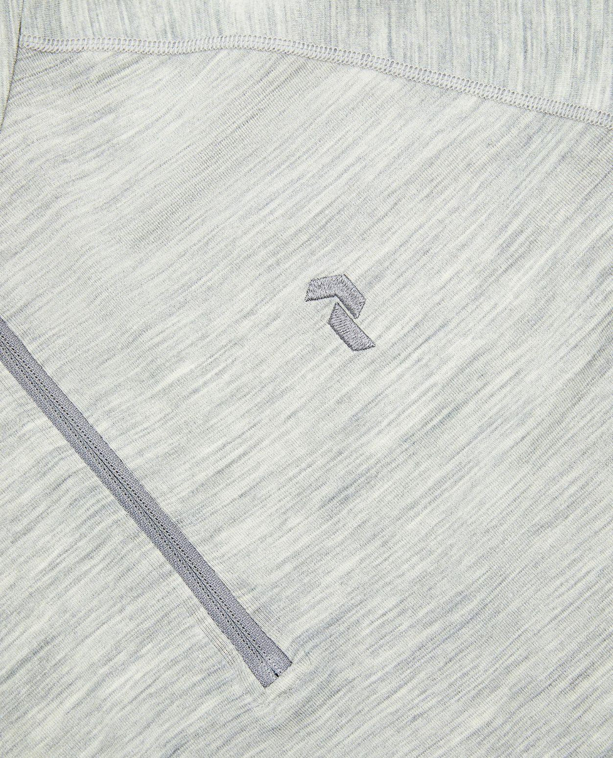 Närbild på Peak Performance Magic Half Zip underställ för herr i grå melange med dragkedja och broderad logotyp.