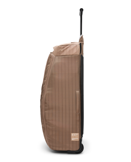 D_b_ Hugger Roller Bag 90L i färg Affogato Brown, en robust resväska med teleskopshandtag för skidresan.