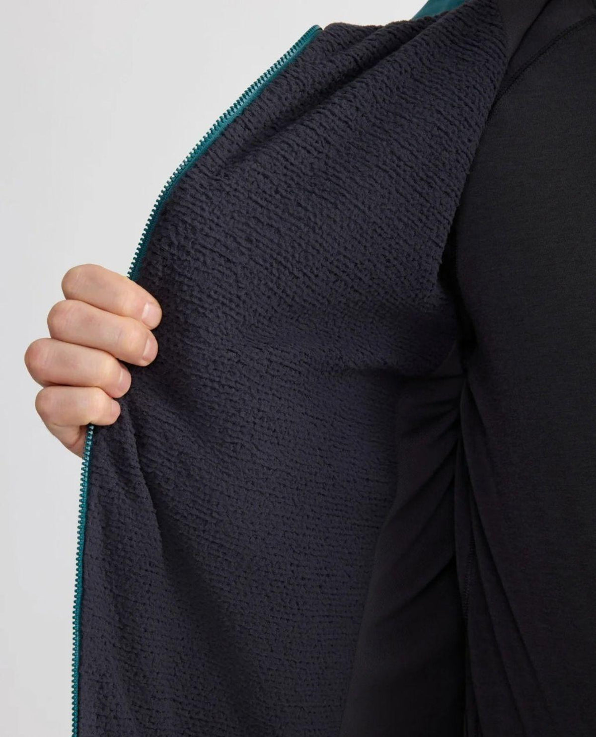 Klättermusen Drifa Hood Jacket Herr - Detaljbild på den stickade PrimaLoft-insidan och dragkedjan i svart.