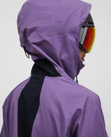 Peak Performance Alpine Gore-Tex 3L Jacka Dam i lila Montana Grape bakifrån med huva och skidglasögon