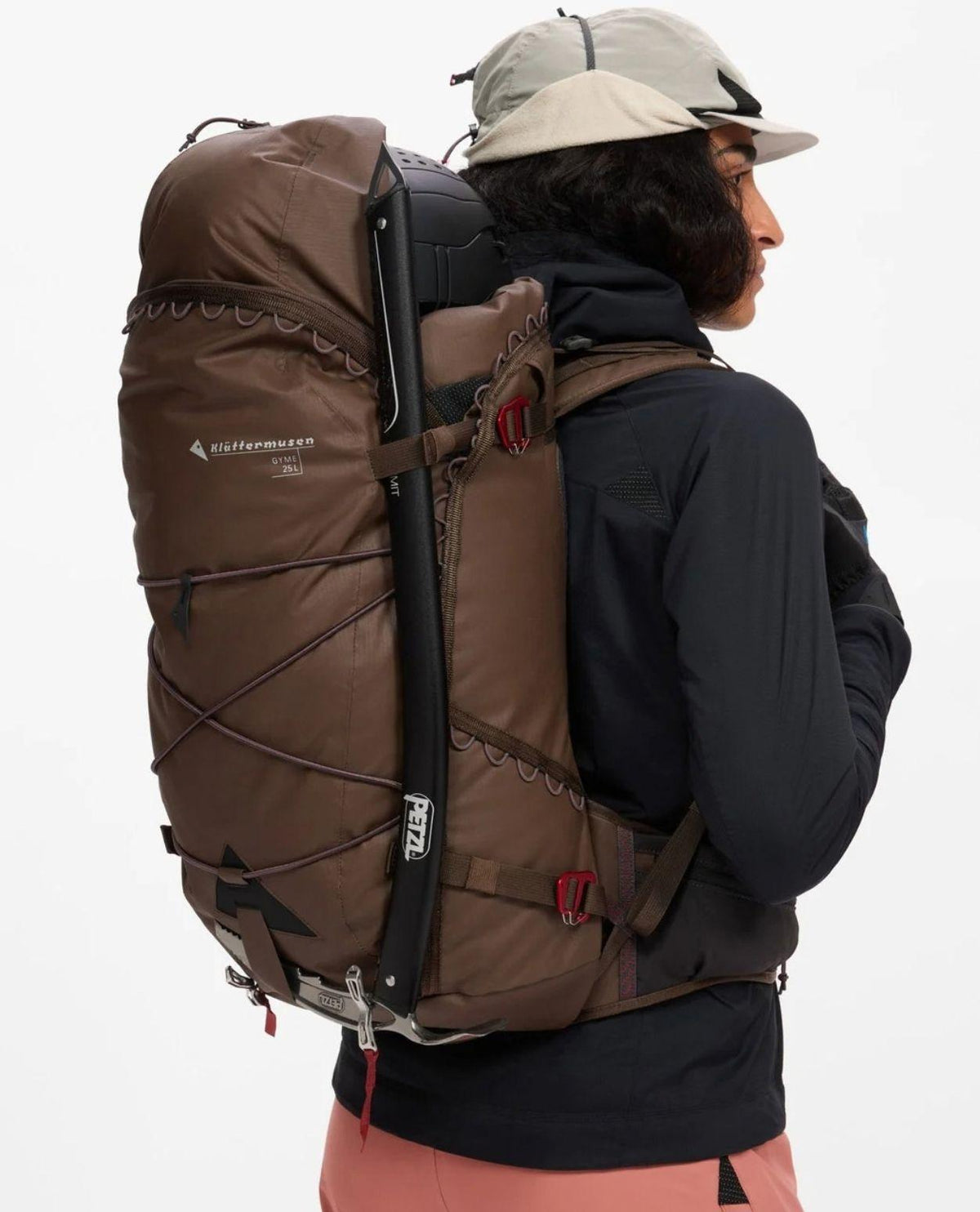 Klättermusen Gyme Backpack 25L i färgen Slate Brown buren på ryggen under en topptur i alpin terräng.