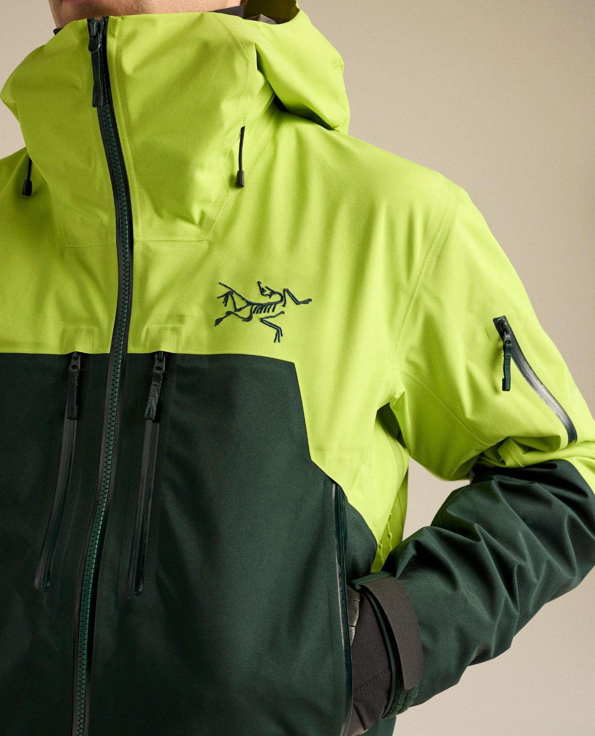 Närbild på bröstpartiet med logotyp på Arc'teryx Rush Jacket för herrar i färgerna mantis och dark jade.