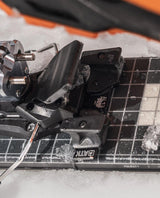 ATK AL13 Freeride Spacer monterad på en skida med snö och vattendroppar.