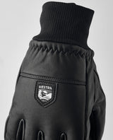 Hestra Omni 5 Finger skidhandske i svart läder med ribbstickad mudd och logotyp.