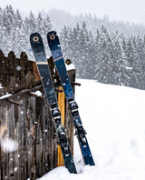 Blizzard Anomaly 88 allmountainskidor lutade mot ett trästaket i snöfall framför en snötäckt skog.