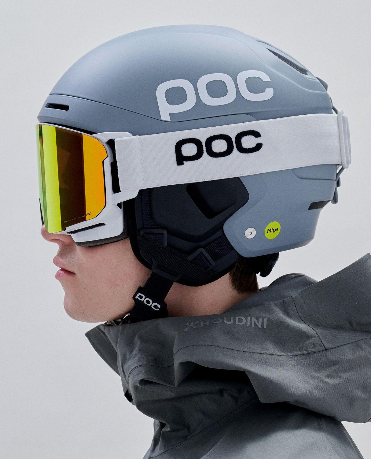 POC Nexal skidglasögon i Hydrogen White med orange lins på skidåkare i profil med hjälm.