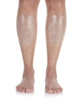 Person visar Sidas Shin Protector EVO på båda smalbenen mot en vit bakgrund.
